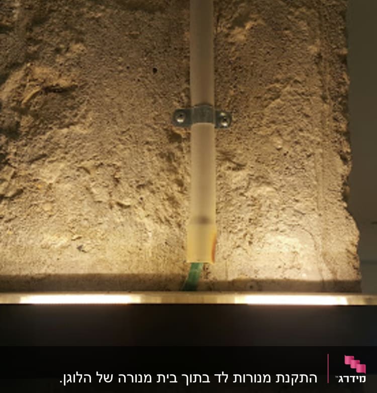 תאורה מותקנת על קיר בטון עם צינור חשמל